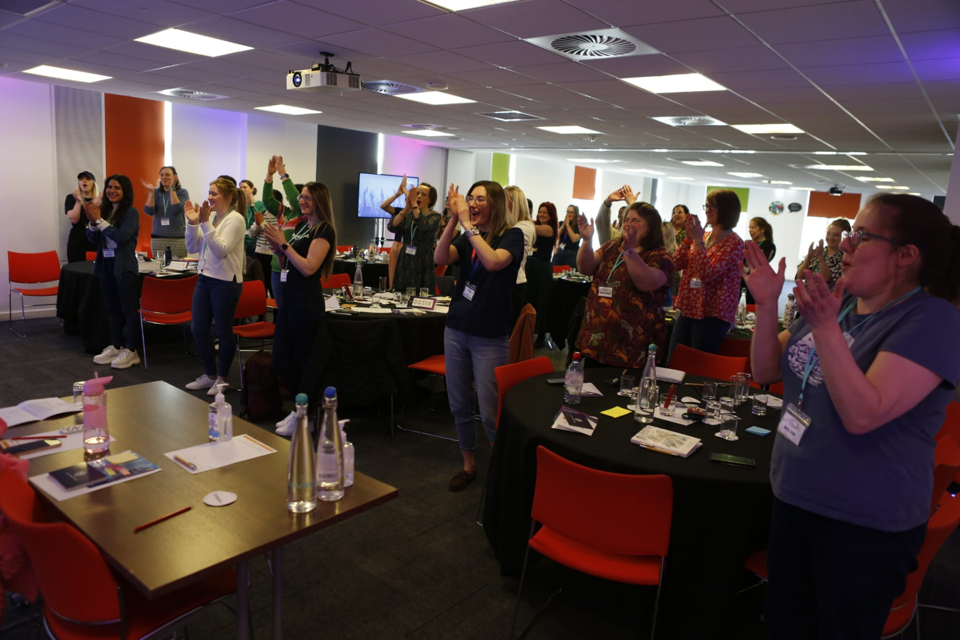 A room of veterinary professionals on their feet, applauding